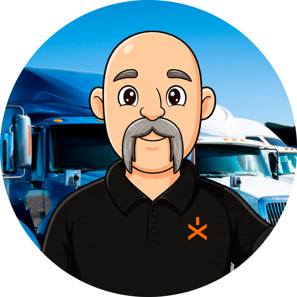 Cartoon mascot of a smiling, bald man with a gray mustache wearing a black polo, standing in front of blue semi-trucks in a truck yard